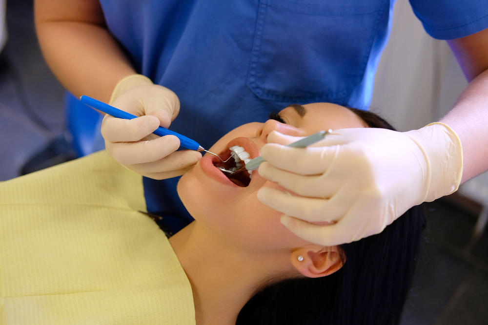 A dentist performing a cleaning or dental checkup on a patient using dental tools - Puyallup Dentist A dentist performing a cleaning or dental checkup on a patient using dental tools - Puyallup Dentist