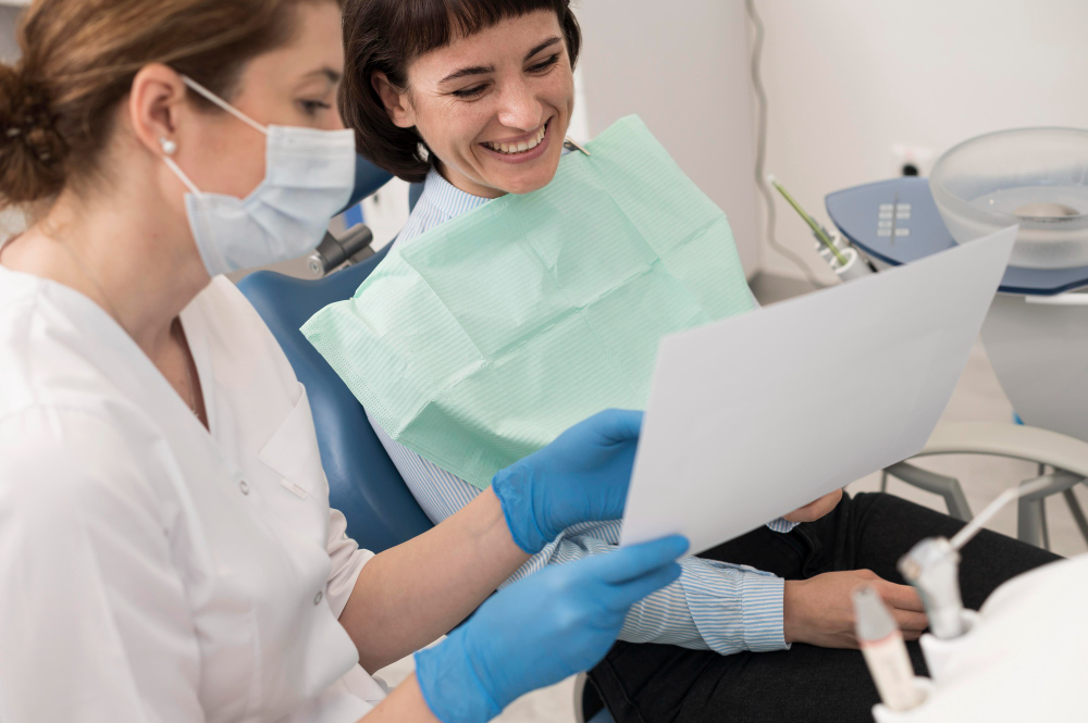 A dentist showing a patient a document, likely explaining treatment or diagnostic results, while the patient smiles and listens attentively - Puyallup Dentist A dentist showing a patient a document, likely explaining treatment or diagnostic results, while the patient smiles and listens attentively - Puyallup Dentist